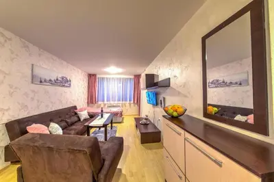 a living room with a couch and a table at Форест Нук - апартамент in Pamporovo