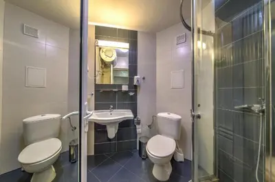 a bathroom with two toilets and a sink and a shower at Форест Нук - апартамент in Pamporovo