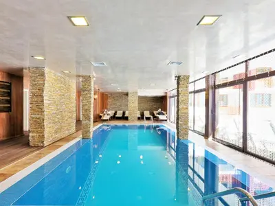 a large swimming pool in a hotel room at Форест Нук - апартамент in Pamporovo