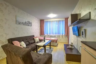 a living room with a couch and a table at Форест Нук - апартамент in Pamporovo