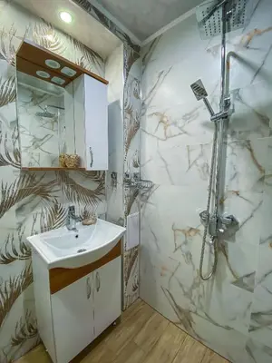 a bathroom with a shower and a white sink at Apartament Tiana Lux in Hisarya