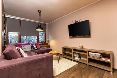 a living room with a couch and a flat screen tv at Dufti Home in Plovdiv Center & Old Town / Kapana in Plovdiv