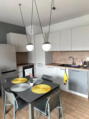 a kitchen with a black table with yellow cushioned chairs at 7th Sense boutique apartments in Sofia