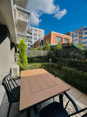 a wooden table and chairs on a patio at 7th Sense boutique apartments in Sofia