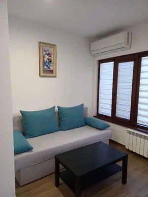 a couch with blue pillows in a living room at Къща за гости Елит (Guest House Elite) in Sapareva Banya