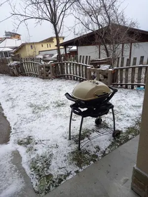 a grill sitting in the snow in a yard at Къща за гости Елит (Guest House Elite) in Sapareva Banya