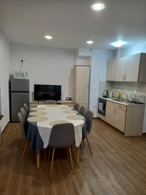 a room with a table and chairs and a kitchen at Къща за гости Елит (Guest House Elite) in Sapareva Banya