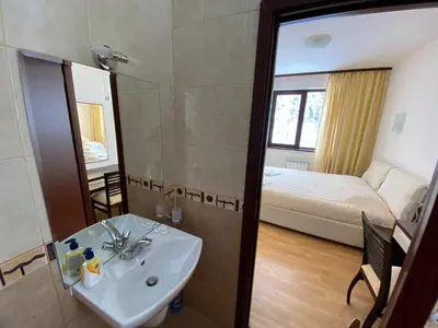 a bathroom with a sink and a mirror and a bed at Charming Winter Studio in Borovets