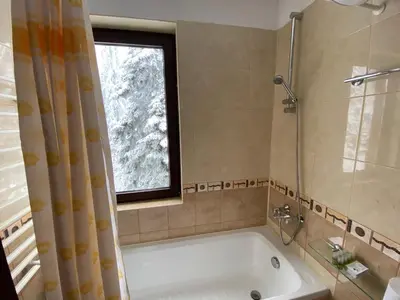 a bathroom with a bath tub and a window at Charming Winter Studio in Borovets
