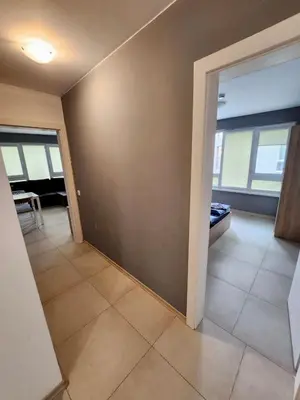 an empty living room with a room with a couch and windows at Top location apartment in Sofia