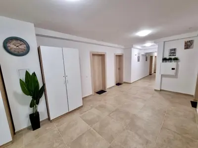 a hallway with white cabinets and a clock on the wall at Top location apartment in Sofia