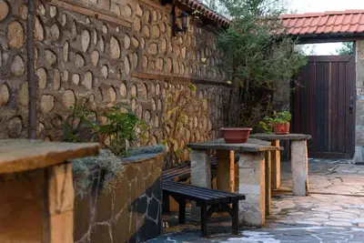 a stone wall with two tables and a bench at Cosy room in the center of Bansko in Bansko