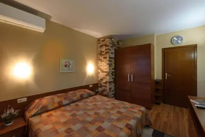a bedroom with a bed and a clock on the wall at Cosy room in the center of Bansko in Bansko