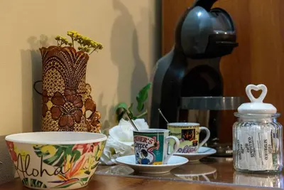 a table with three cups and a coffee maker at Cosy room in the center of Bansko in Bansko
