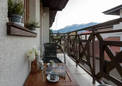 a table on a balcony with a view of the mountains at Cosy room in the center of Bansko in Bansko