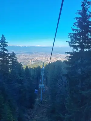a gondola ride up a mountain with trees at Bansko Royal Towers apartment 200m from skilift in Bansko