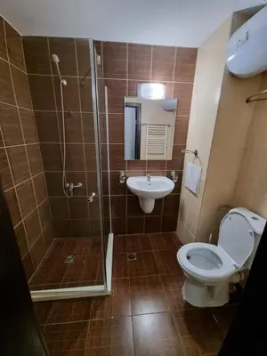 a bathroom with a shower and a toilet and a sink at Bansko Royal Towers apartment 200m from skilift in Bansko
