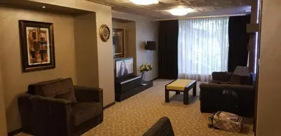 a living room with chairs and a flat screen tv at Suite Roma 1 at Royal Spa in Velingrad