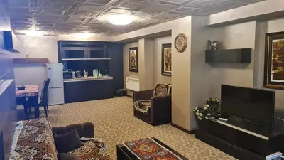 a living room with a couch and a tv and a kitchen at Suite Roma 1 at Royal Spa in Velingrad
