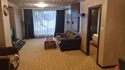 a living room with two chairs and a couch in a hotel room at Suite Roma 1 at Royal Spa in Velingrad