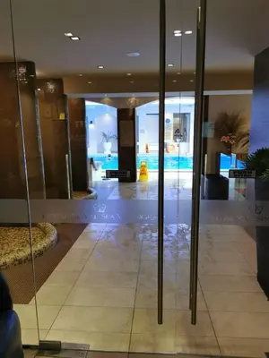 a lobby with glass doors and a pool in the background at Suite Roma 1 at Royal Spa in Velingrad