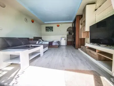 a living room with a couch and a flat screen tv at Apartments Dream in Sarnitsa