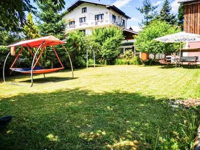 a yard with a swing and an umbrella at Apartments Dream in Sarnitsa