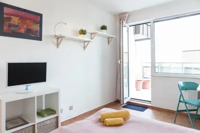 a living room with a tv and a bed and a window at Tony's Sunny Rooftop Studio by Flat Mаnager in Sofia