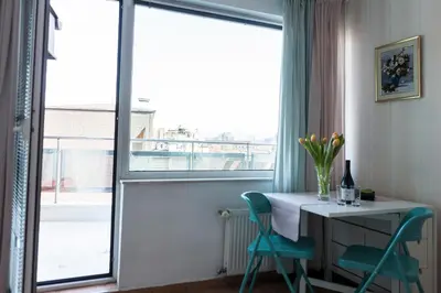 a room with a table and chairs and a window at Tony's Sunny Rooftop Studio by Flat Mаnager in Sofia