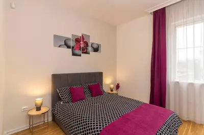 a bedroom with a black and white bed with purple pillows at Spacious Aristocratic Apt. with a Colourful View in Sofia