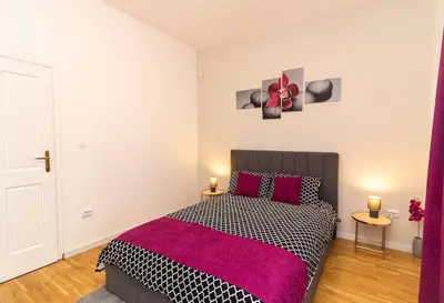 a bedroom with a black and white bed with red pillows at Spacious Aristocratic Apt. with a Colourful View in Sofia