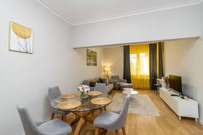 a living room with a table and chairs and a couch at Spacious Aristocratic Apt. with a Colourful View in Sofia