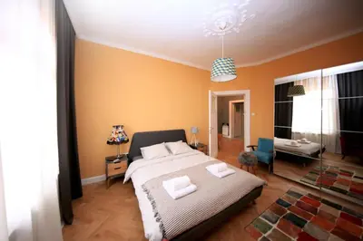 a bedroom with a large bed and a living room at *CITADEL* 2BR - city center in Sofia