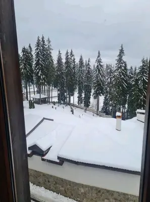 a view of a snow covered ski slope from a window at Apartment Svetoslava in Pamporovo