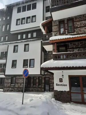 a street sign in the snow in front of a building at Apartment Svetoslava in Pamporovo