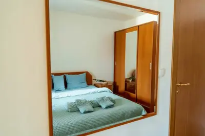 a reflection of a bedroom with a bed in a mirror at Large 2-bedroom apt near ski road, 5 min to Gondola & Bar Street in Bansko
