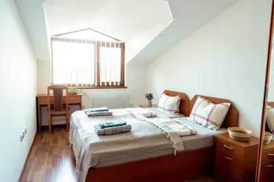 a bedroom with a bed with a desk and a window at Large 2-bedroom apt near ski road, 5 min to Gondola & Bar Street in Bansko