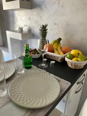 a table with plates and bowls of fruit on it at Elegant Stay in the Heart of Plovdiv Old Town in Plovdiv