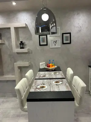 a dining room with a table and white chairs at Elegant Stay in the Heart of Plovdiv Old Town in Plovdiv