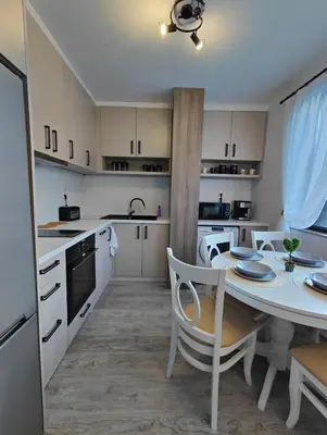 a kitchen with a table and a dining room at Апартамент РАЯ in Chepelare