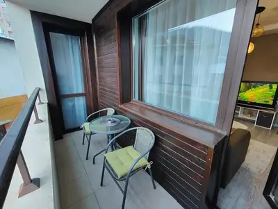 a balcony with a table and chairs and a window at Апартамент РАЯ in Chepelare