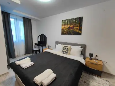 a bedroom with a large bed with two towels on it at Апартамент РАЯ in Chepelare