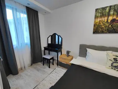 a bedroom with a bed and a table with a chair at Апартамент РАЯ in Chepelare