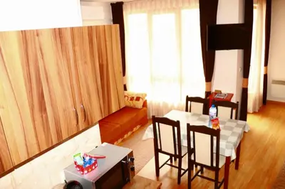 a living room with a couch and a table and chairs at Pirin Palace in Bansko