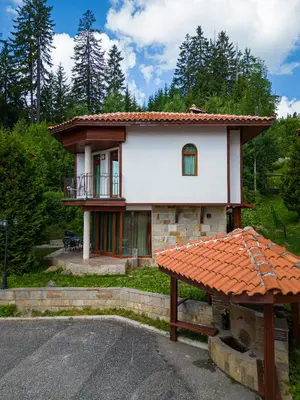 a small house with a porch and a balcony at Pamporovo Cottage Savov in Pamporovo
