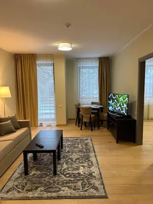 a living room with a couch and a table at Lodge Euphoria Apartment in Borovets