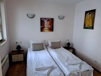 a bedroom with a bed with white sheets and pillows at Private Chalets Bansko in Bansko