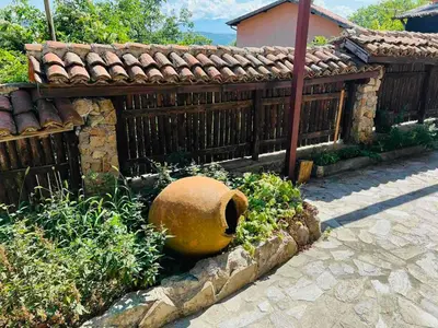 a large vase sitting in a garden next to a fence at Къща за гости Под Манастира in Skrino