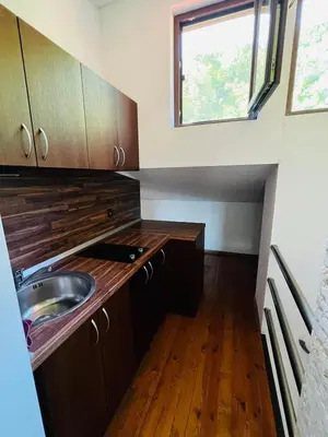 a small kitchen with a sink and a window at Къща за гости Под Манастира in Skrino