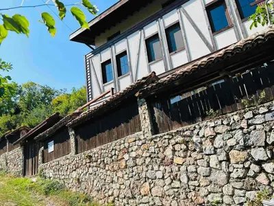 a stone building with windows on top of it at Къща за гости Под Манастира in Skrino